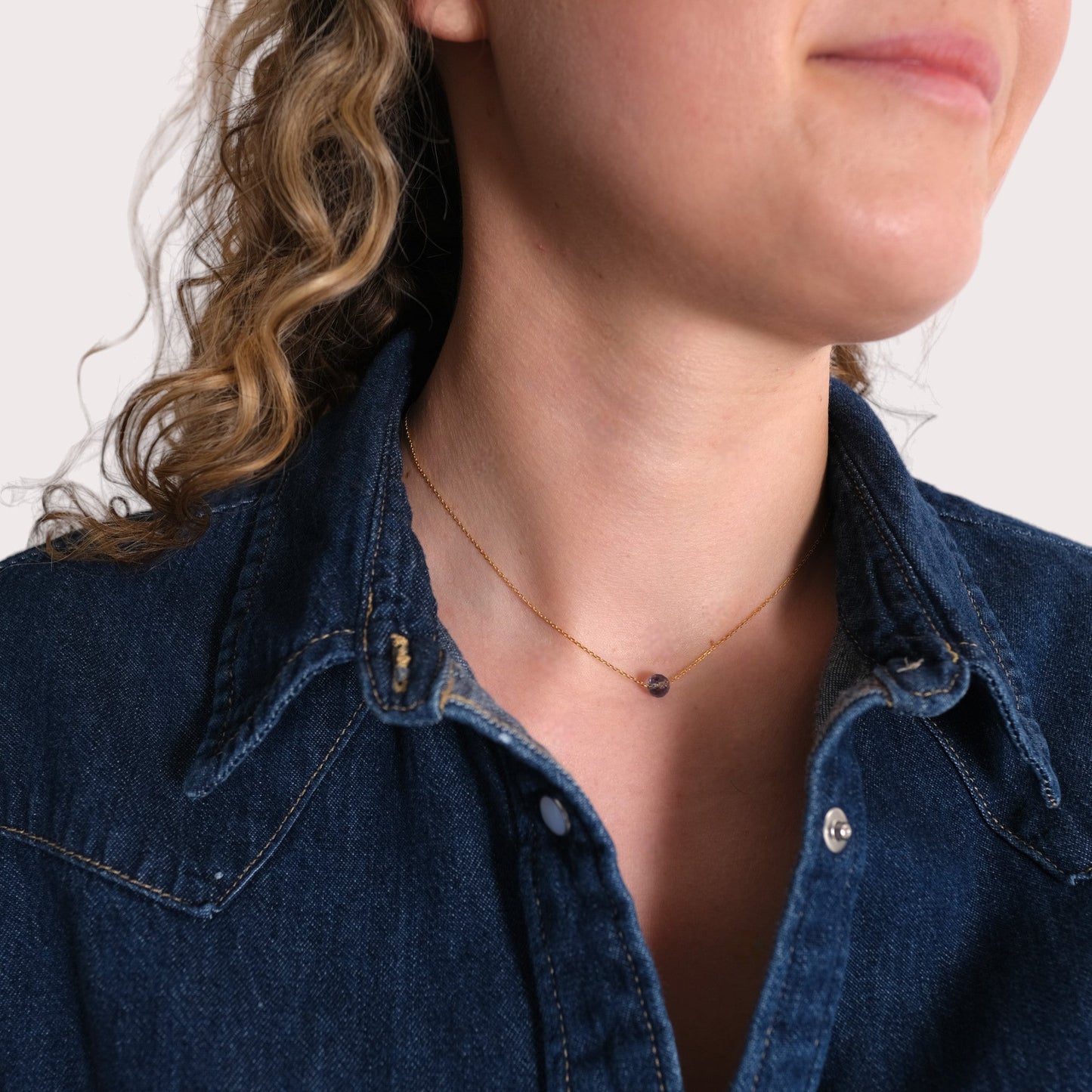Geburtsstein Kette Dezember mit blauem Topas, Geburtsstein Dezember für Schütze, getragen von Frau mit Jeanshemd.