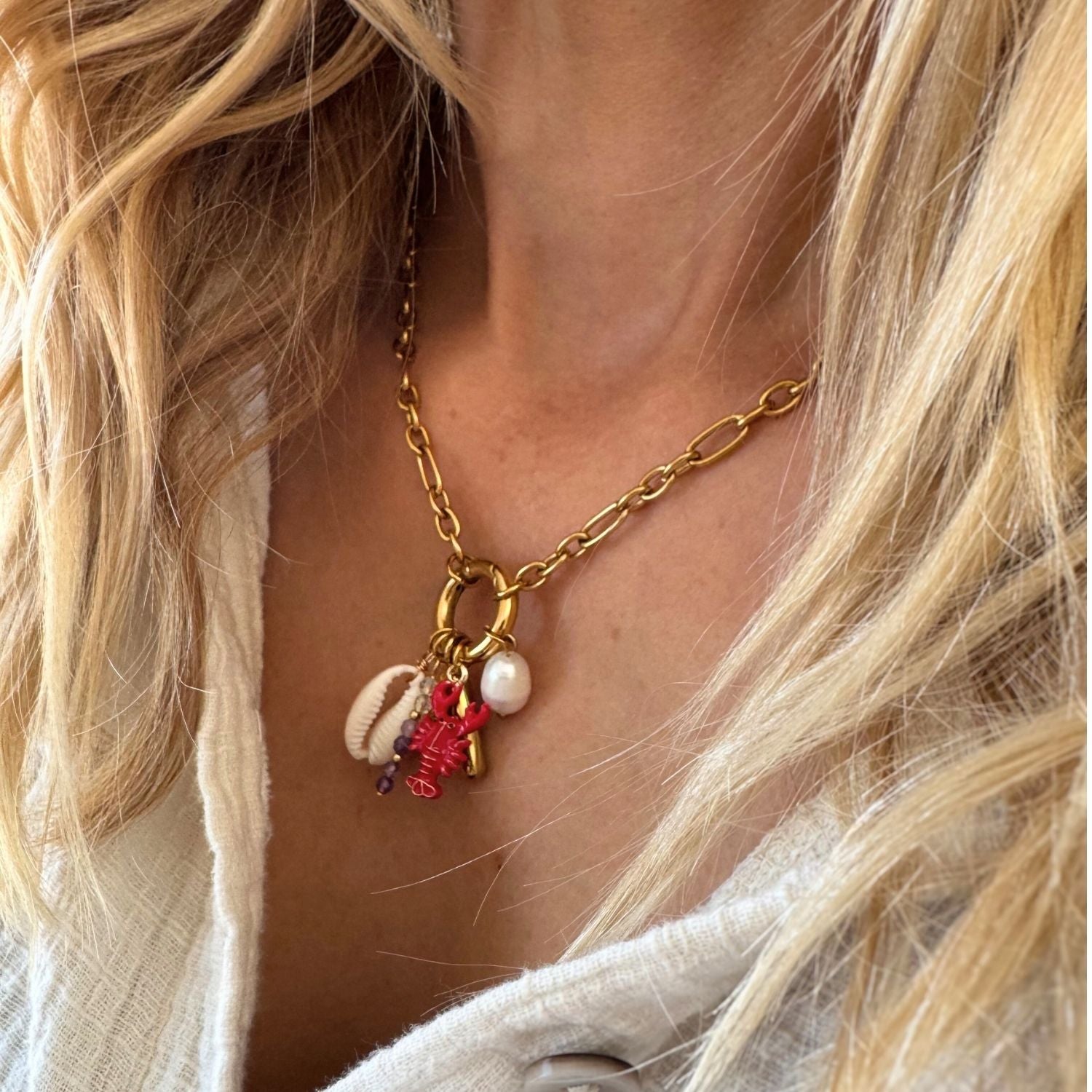 Charm Kette aus vergoldetem Edelstahl mit Karabiner und unterschiedlichen Anhängern.