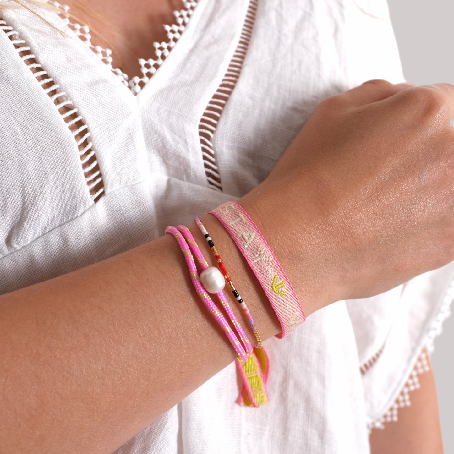 pink Segeltau Armband with freshwater pearl and neon pink adjustable knots on wrist