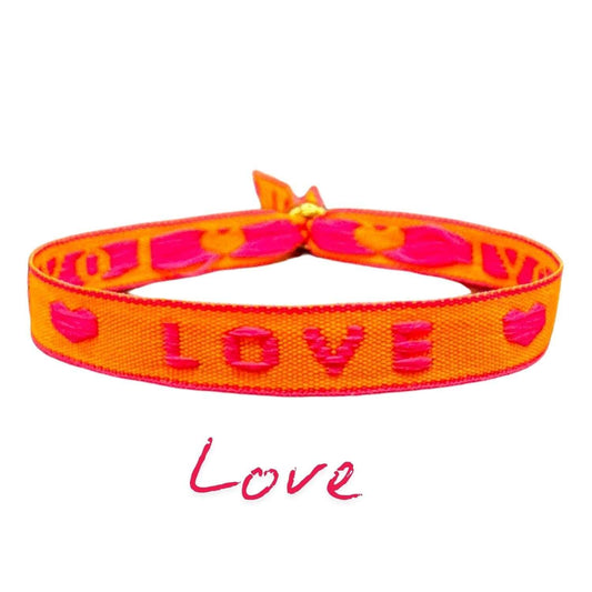 Neon orange statement armband with "Love" text, adjustable and water-resistant; perfect for festivals and boho style.
