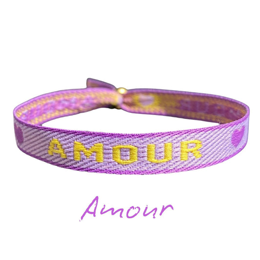 Statement Armband "Amour" in lila mit gelbem Schriftzug, anpassbare Größe, wasserfestes Material.