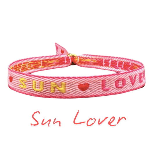 Statement Armband "Sun Lover" in Rosa mit gelber Schrift und Herzmotiv - Sommerliches Stoffarmband für Boho Style.