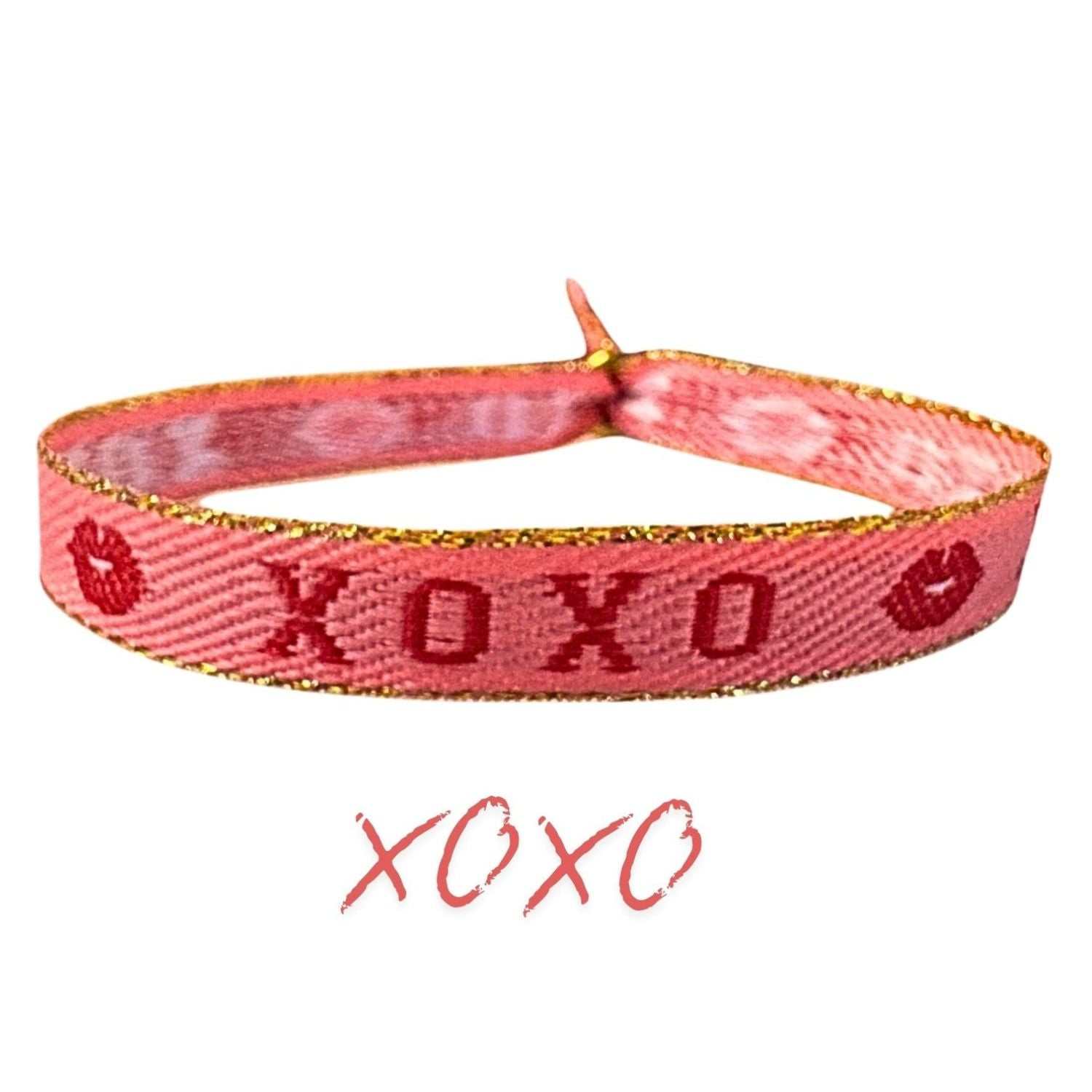 Red and pink "Statement Armband - XOXO" with kisses and hugs design, adjustable and waterproof.