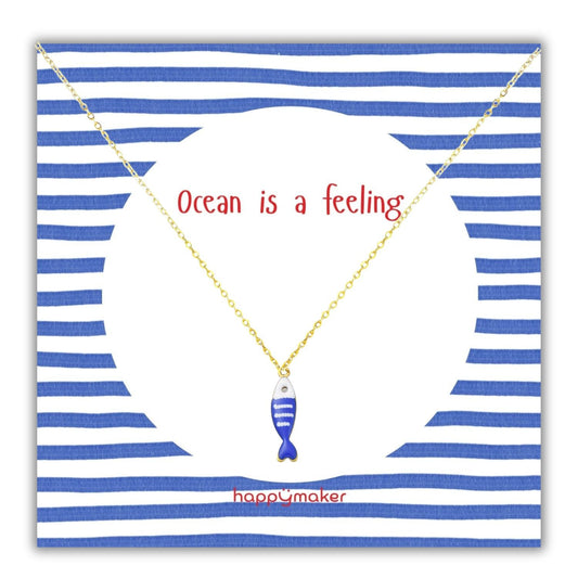 Goldkette mit blau-weißem Fischanhänger auf maritim gestalteter Karte, "Ocean is a feeling" Text.