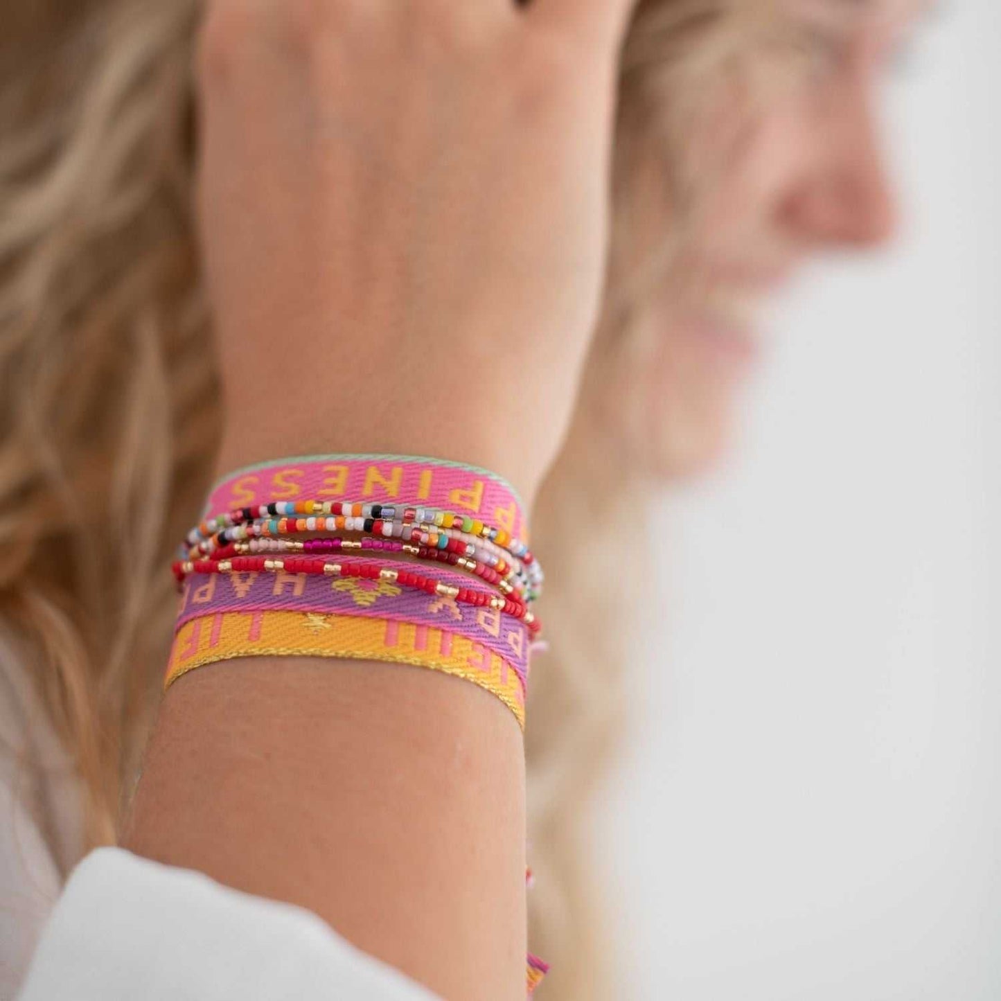 Colorful statement armband "Carpe Diem" on wrist, made of soft textile with adjustable sliding bead