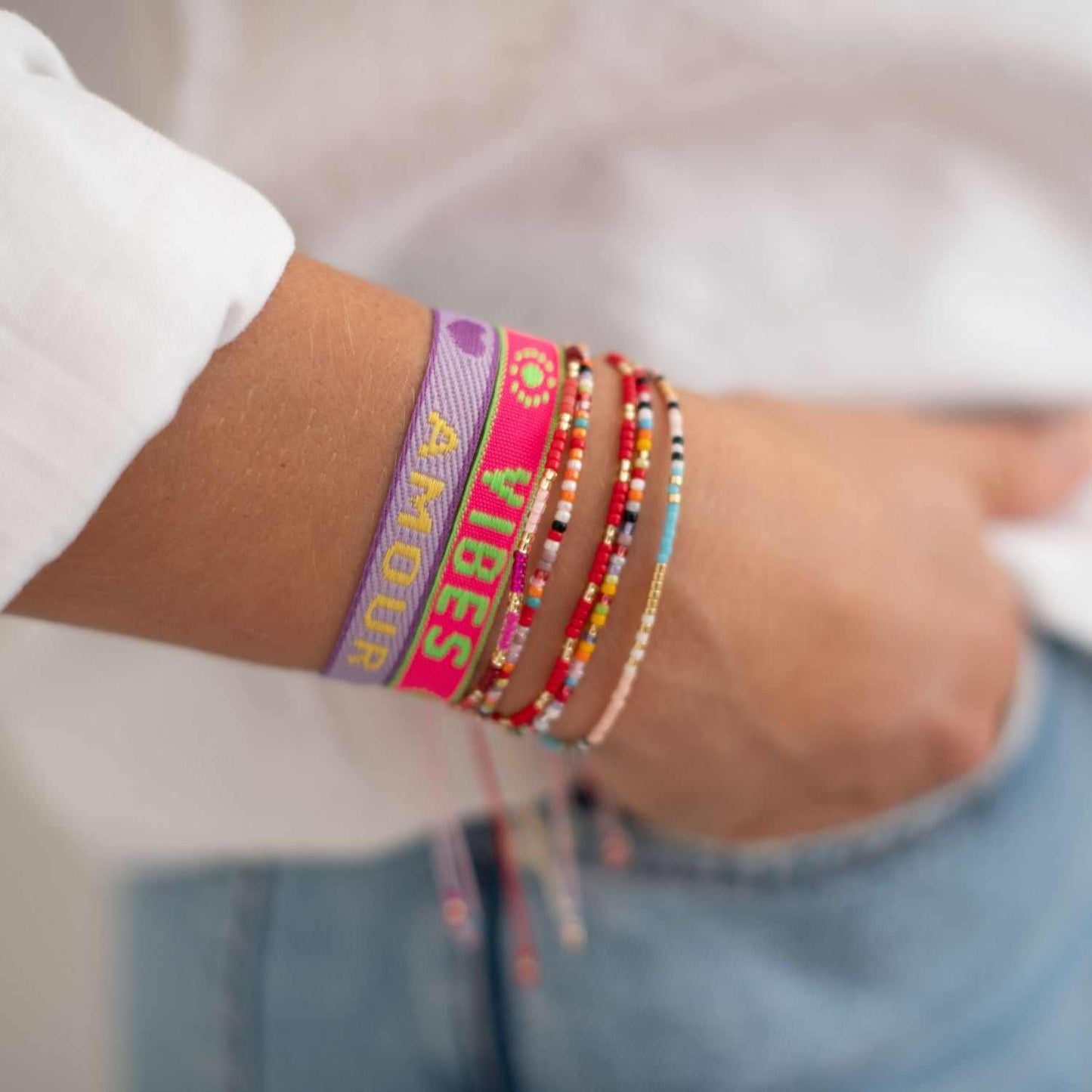 Statement Armbänder am Handgelenk, kombiniert mit bunten Perlenarmbändern.
