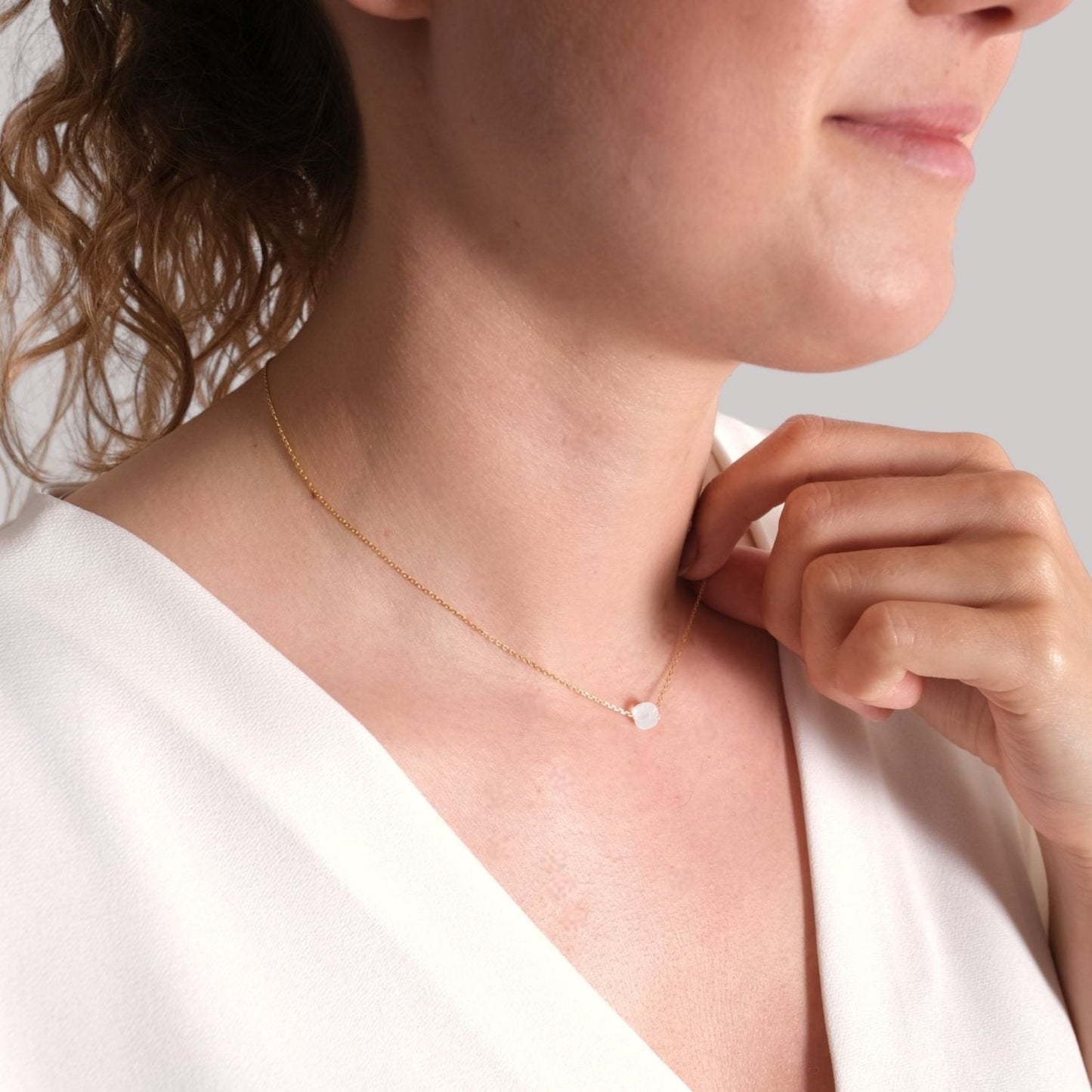 vergoldete Silberkette mit Opal-Geburtsstein für Waage am Hals einer Frau, symbolisiert Balance und Schönheit.