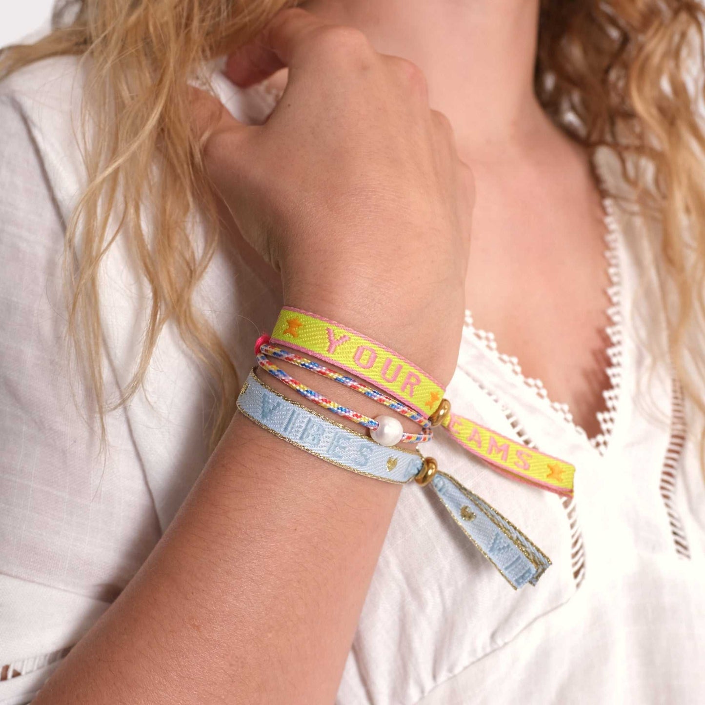 Hellblaues Statement-Armband mit „Good Vibes“-Schriftzug, verstellbare Schiebeperle, zum Tragen am Handgelenk.